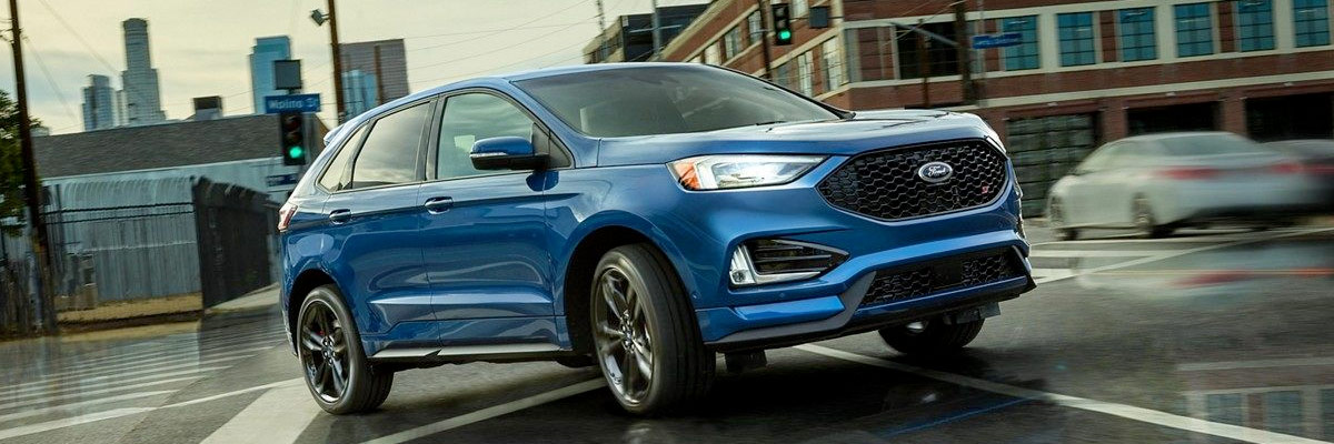 blue 2019 Ford Edge making a turn on a city street