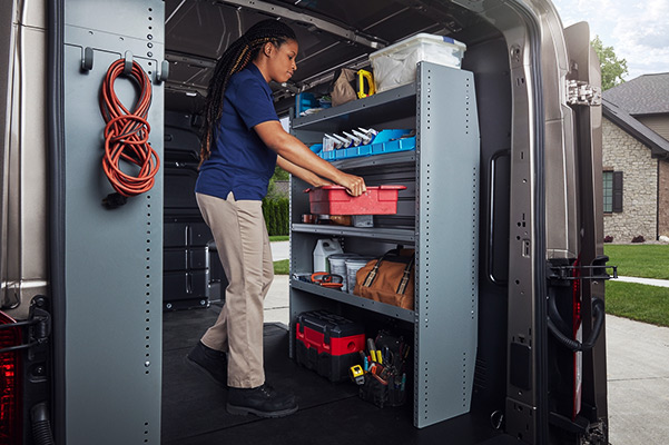 Service worker organizing shelves in the back of a 2020 Ford Transit van