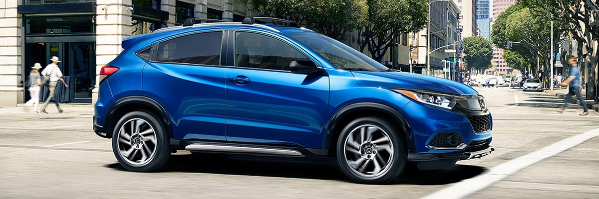 Side shot of 2020 Honda HR-V driving down busy city street during the day.