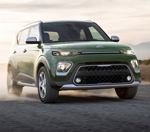 Green Kia Soul driving on a dirt road