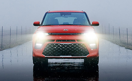 Front view of red Kia Soul on rainy day