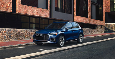 3/4 exterior shot of the 2021 Audi Q5 in front of a modern style building