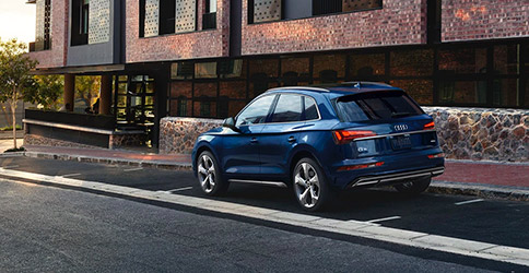 Rear exterior shot of the 2021 Audi Q5 in front of a modern style building