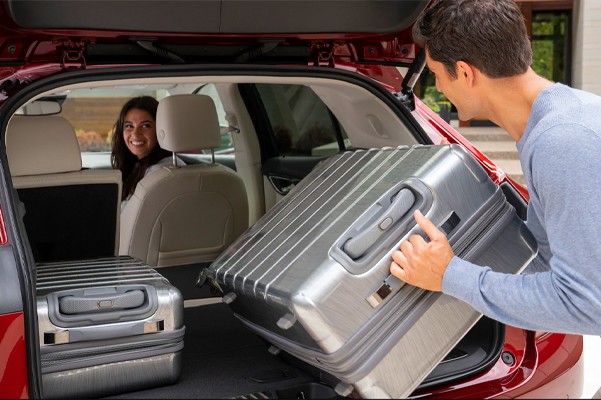 Person loading lugage into the rear of the 2021 Buick Envision