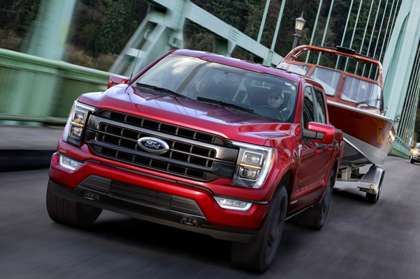 Front shot of Ford F-150 towing a boat over a bridge in day