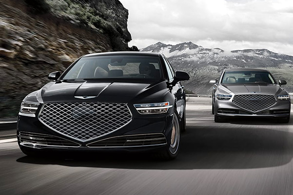 2021 Genesis G90 vehicles driving down a scenic road side by side