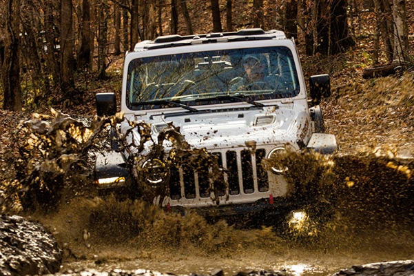 Jeep Wrangler driving through mud