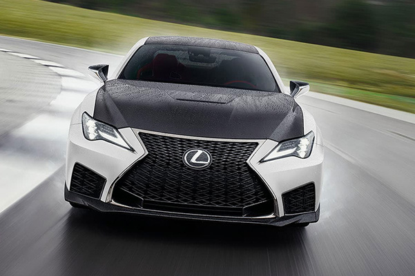 Front view of a 2021 Lexus RC F shown in Artic Blast Satin driving through rain down a slick road