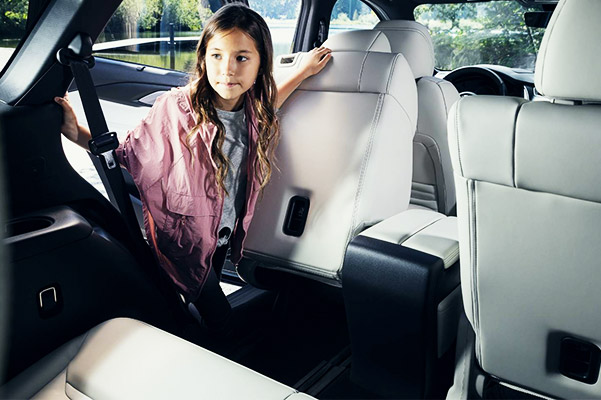 Young girl getting into the back of a 2021 CX-9