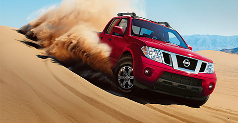 Nissan Frontier driving through sandy dunes
