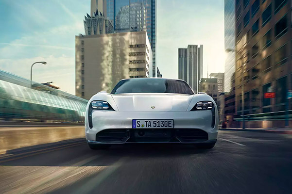 Front view of a 2021 Porsche Taycan driving through the city