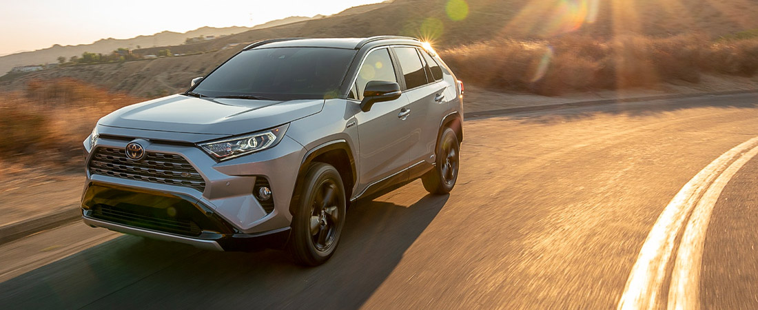 2021 Toyota RAV4 driving down a scenic highway during golden hour