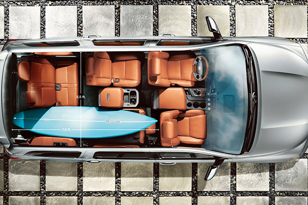 Aerial shot of the interior seating in a Toyota with 3 rows of seats including a surfboard positioned easily across seats