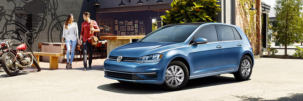 Silk Blue Metallic Golf parked on a city street.