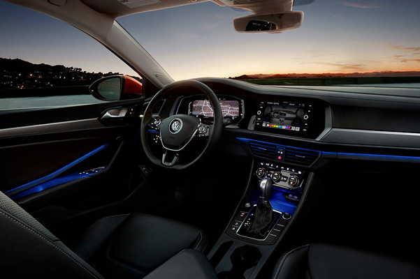 A driver’s view of the Jetta interior in available Titan Black leather seen at night.