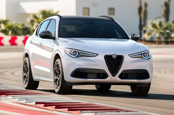 Exterior shot of a 2022 Alfa Romeo Stelvio driving on a track during the day time.