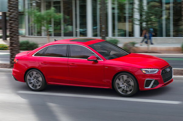 Exterior shot of a 2022 Audi A4 driving down a city street during the day.