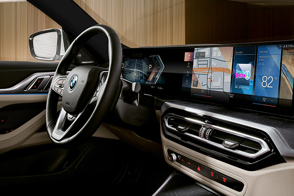 Interior detail shot of a 2022 BMW i4 steering wheel and screen.