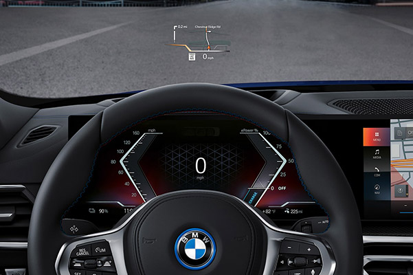 Detail shot of a 2022 BMW i4 steering wheel and dashboard.