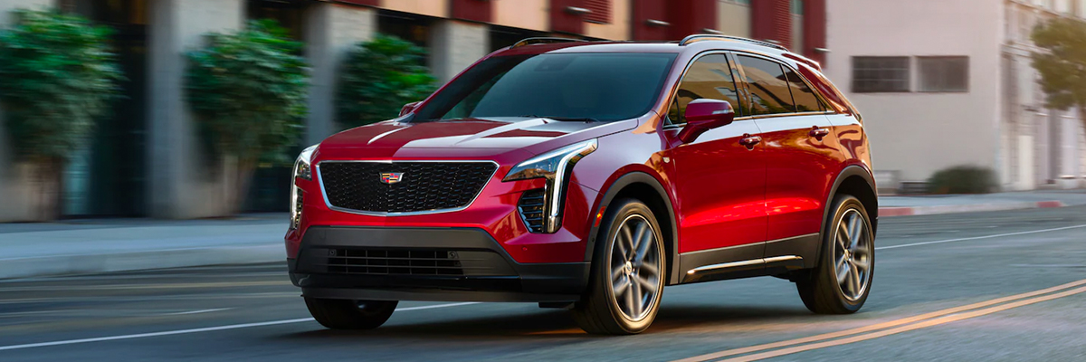 Exterior shot of a 2022 Cadillac XT4 driving down a city street during the day.