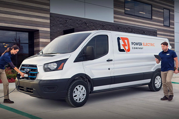 A woman is shown charging a 2023 Ford E-Transit™ vehicle