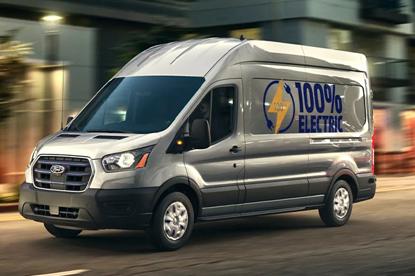 2022 Ford E-Transit with 100 percent Electric decal being driven rapidly down city street