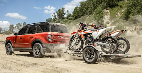 A 2022 Ford Bronco™ Sport towing two dirt bikes off road