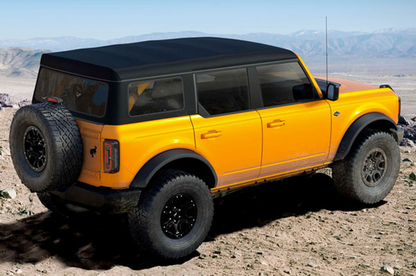 Four door 2022 Ford Bronco™ Wildtrak™ in Cyber Orange Metallic Tri-coat parked on an overlook