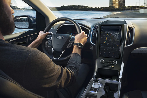 Shot of a man driving a 2022 Ford Edge featuring the interior console