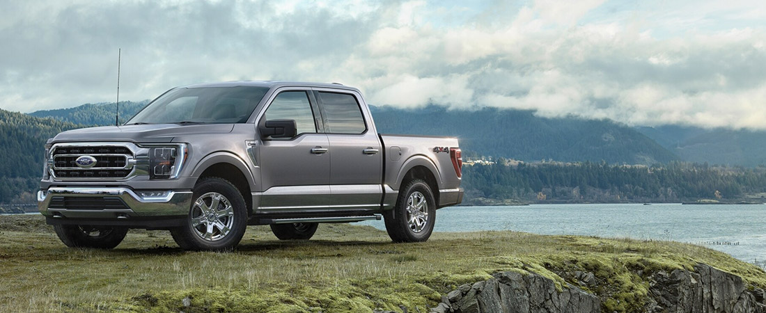 A 2022 Ford F-150 on a grassy cliff near a lake