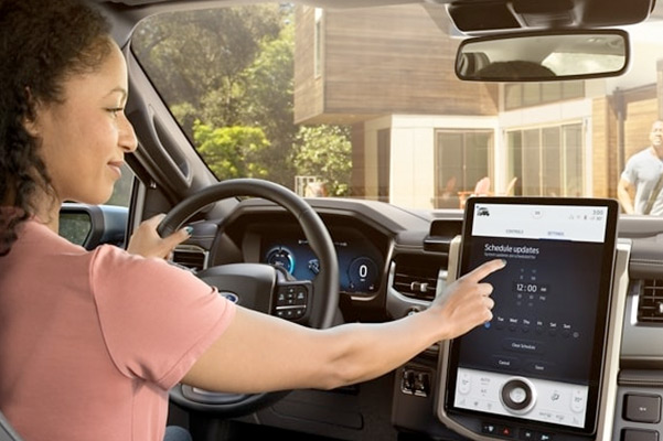 A women inside a 2022 Ford® F-150 Lightning using the touchscreen