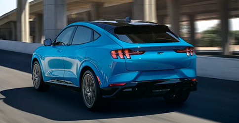 2022 Ford Mustang Mach-E in Grabber Blue on a freeway ramp
