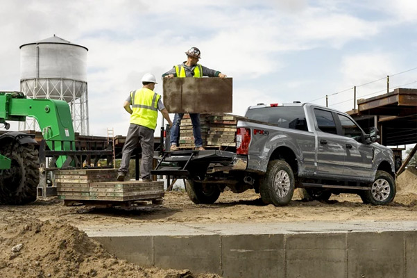 Workers unloading wood pallets from a 2022 Ford Super Duty® F-250 STX