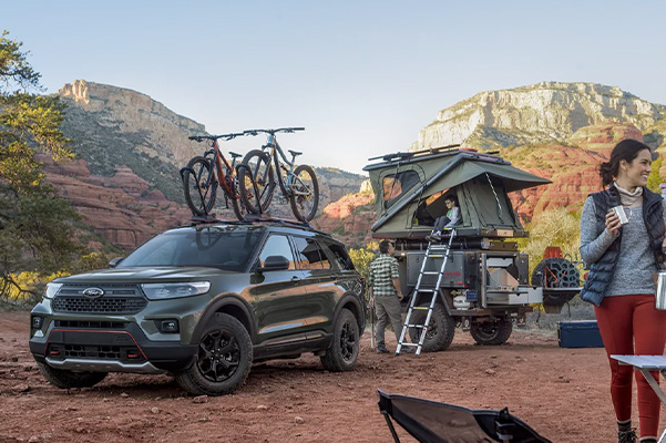	2022 Ford Explorer Timberline™ parked in desert environment with a trailer-top tent and family