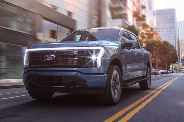 2022 Ford F-150 Lightning driving down a city street.