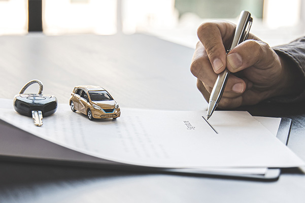 Signing paperwork with car keys on top