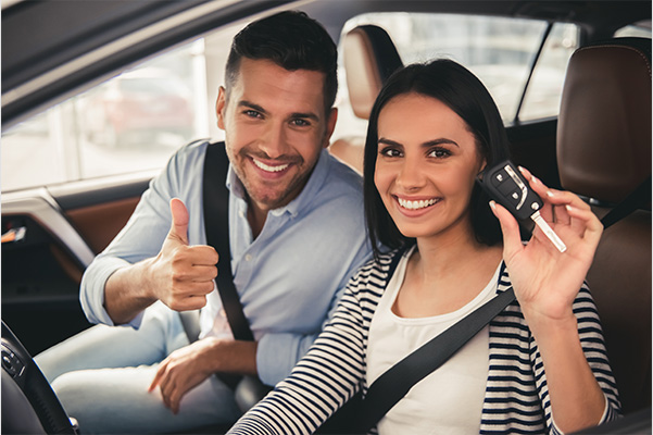 Happy couple with car keys in their hand