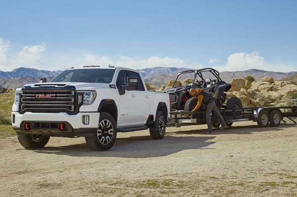 2022 GMC Sierra HD AT4 Off-Road Truck in Desert with Dune Buggies on Trailer