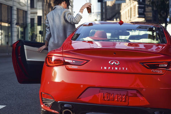 Rear exterior view of woman getting into the driver's seat of the 2022 INFINITI Q50 Coupe