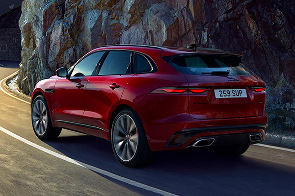Rear view of red 2022 Jaguar F-PACE driving down the road