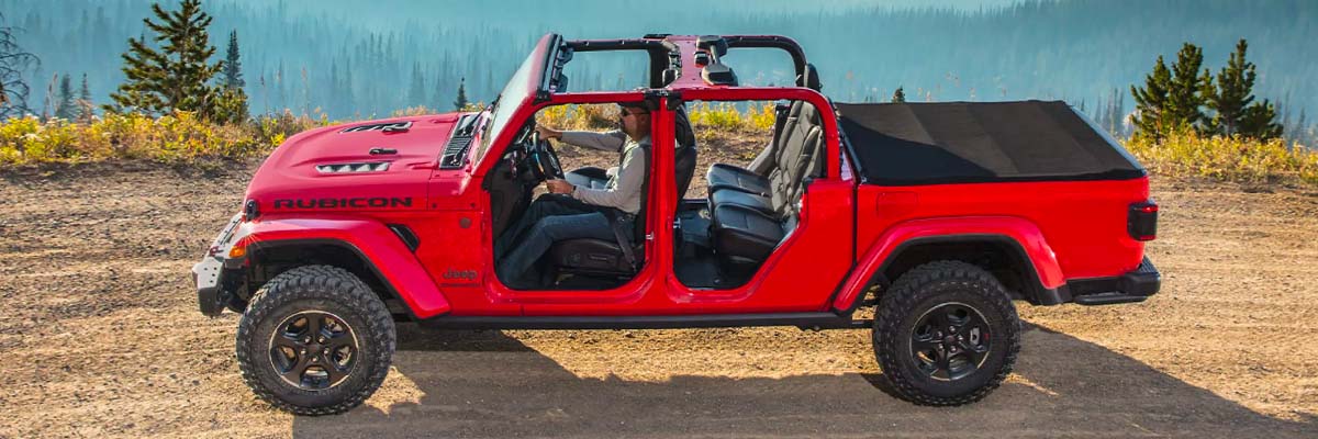 The 2022 Jeep Gladiator Rubicon being driven off-road on a mountain trail with its top and doors off.