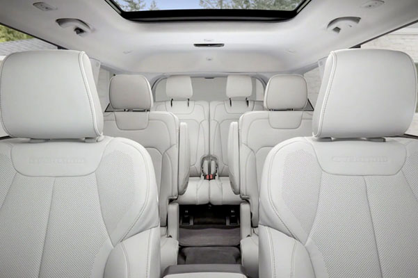 The interior of the 2022 Jeep Grand Cherokee Overland with three rows of seating and an open sunroof.