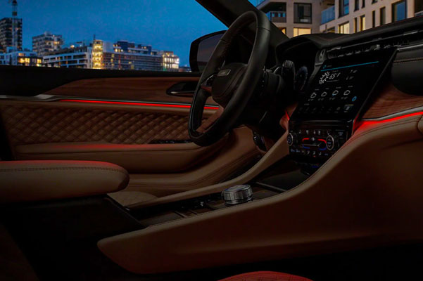 The interior ambient LED lighting system in the 2022 Jeep Grand Cherokee Summit Reserve, giving off a red glow.