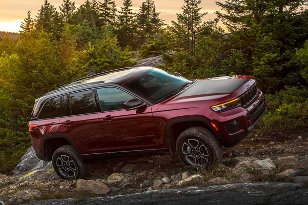 The 2022 Jeep Grand Cherokee driving through the woods.