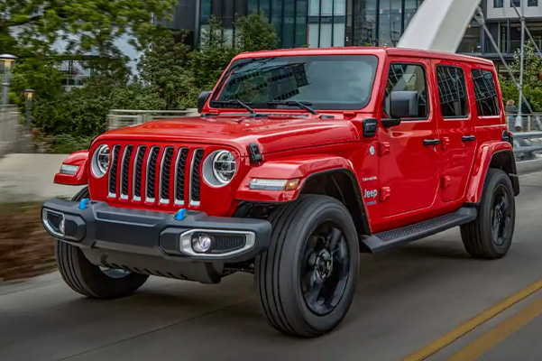 The 2022 Jeep Wrangler 4xe driving down a city street.
