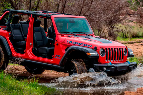 The 2022 Jeep Wrangler Rubicon 4xe with its doors off, entering a stream.