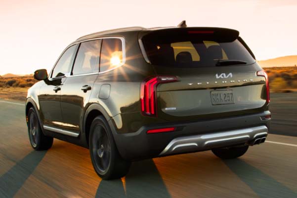 2022 Kia Telluride Driving On The Open Road At Sunset Rear Three-Quarter View