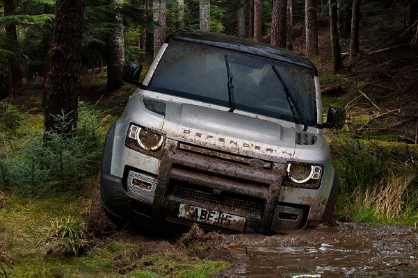 2022 Land Rover Defender driving in mud in the woods