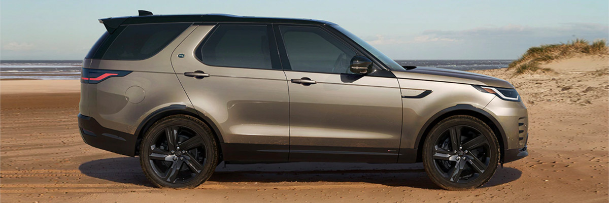Exterior side shot of a 2022 LAND ROVER DISCOVERY parked on a beach