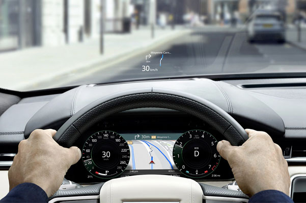 Close up view of a person holding the steering wheel in a 2022 Range Rover Velar. IN-CAR TECHNOLOGY shown